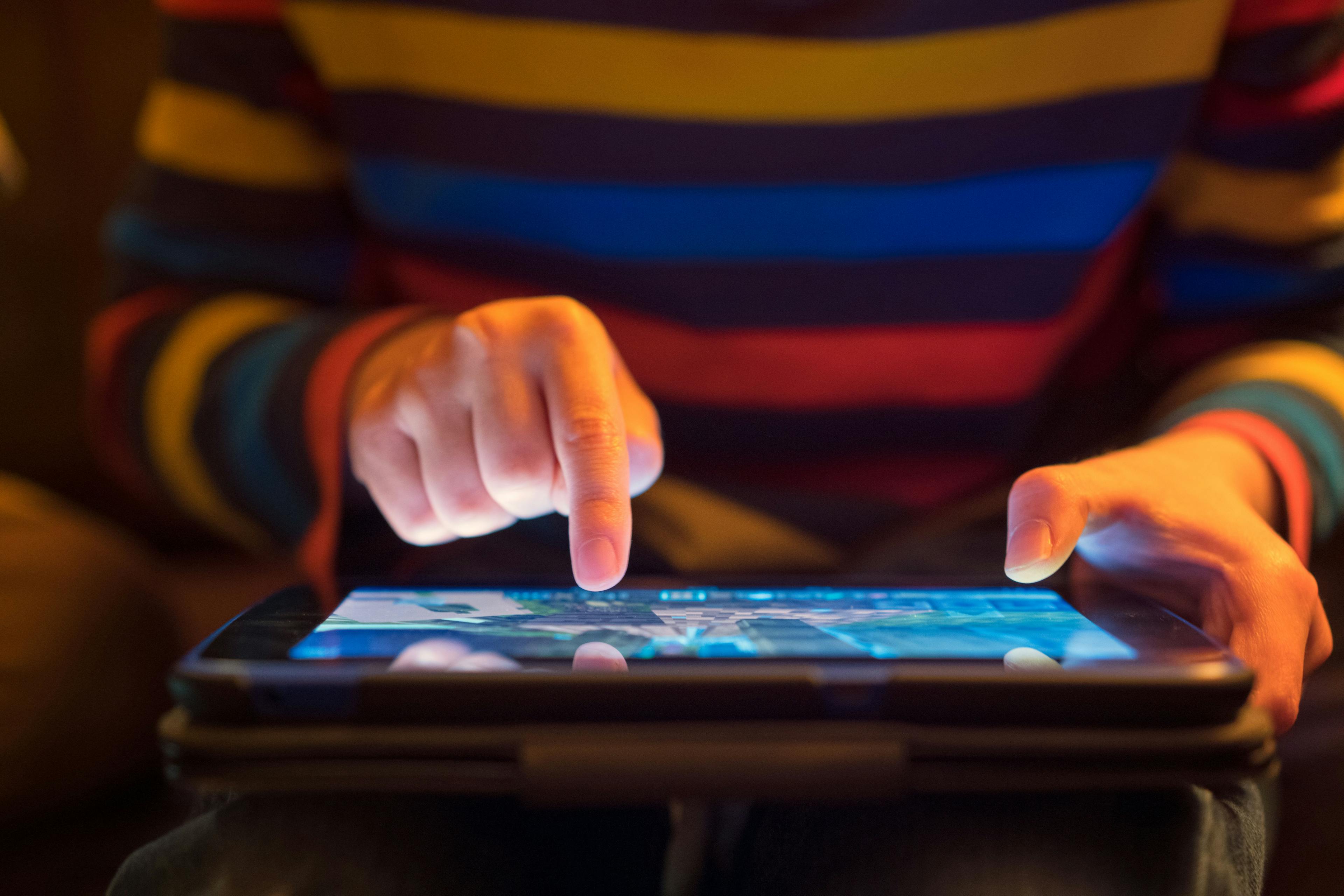 Close up of child using a tablet.