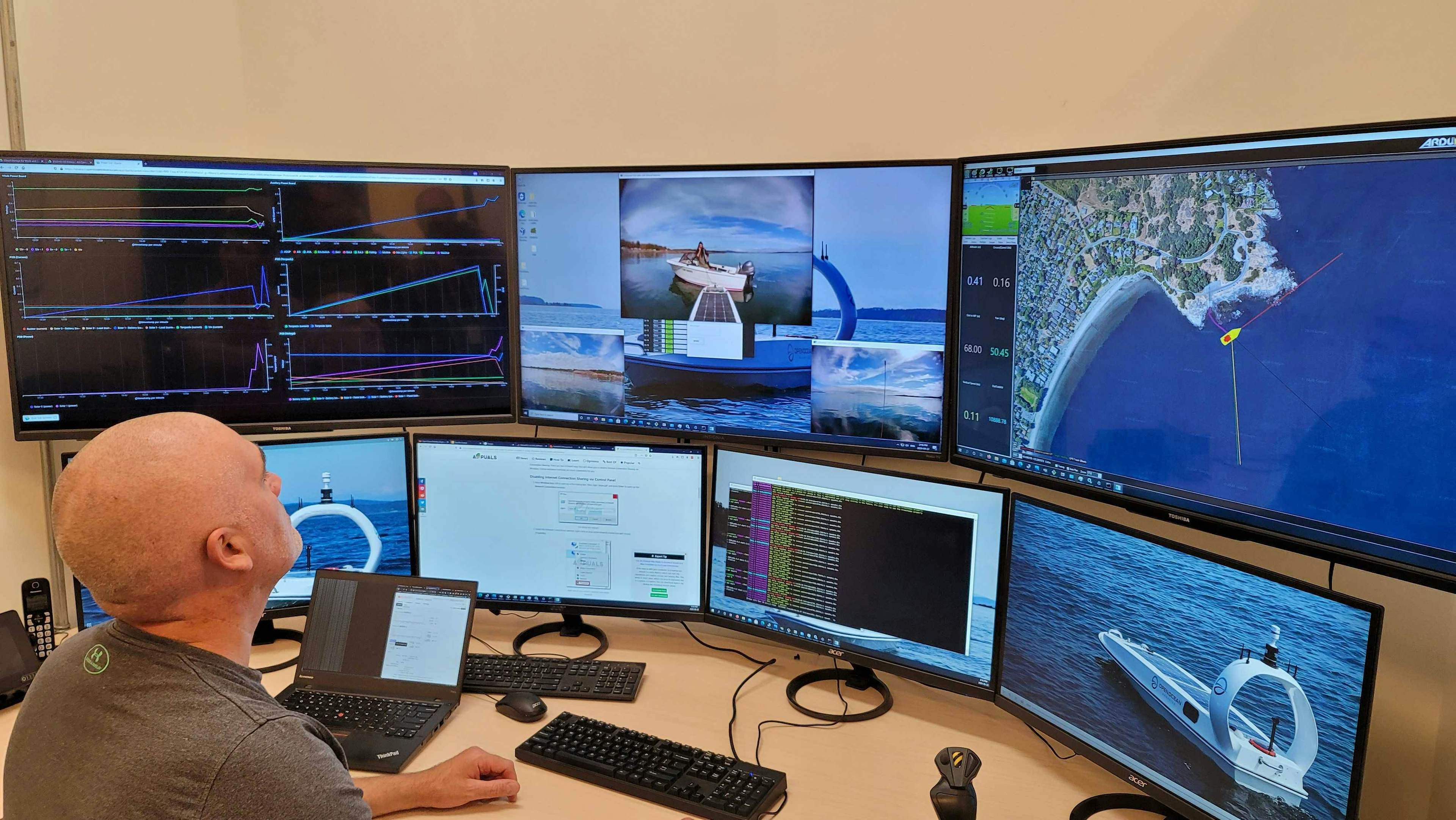 Open Ocean Robotics employee sitting in front of a bunch of screens monitoring ocean drone